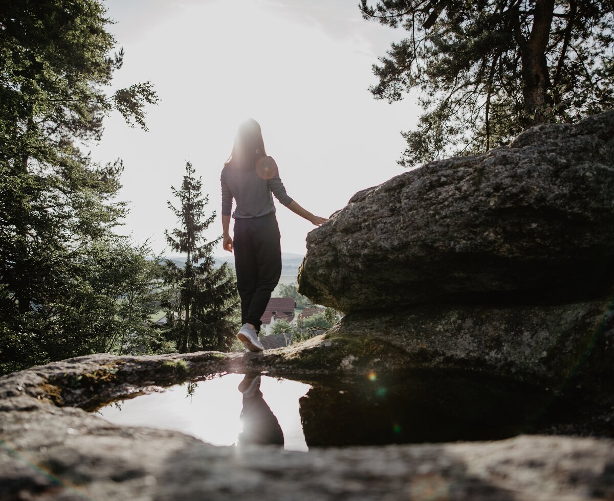 Frau steht an einem Granitfelsen, Mühlviertel | © Oberösterreich Tourismus GmbH / Patrick Langwallner
