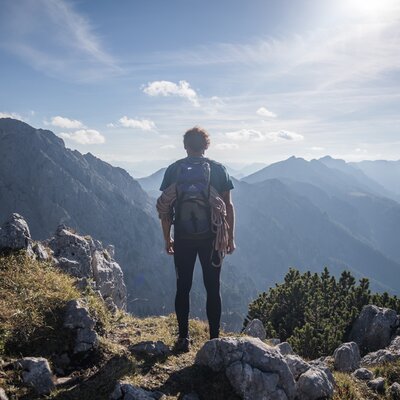 Bergsteiger steht am Gipfel mit Blick in die Berge der Nationalparkregion Kalkalpen | © Oberösterreich Tourismus GmbH / Robert Maybach