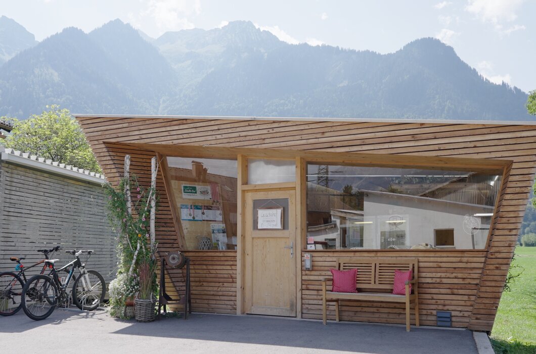 Holzkonstruktion mit Terrasse und Sitzbänken im Freien, umgeben von Bergen und Vegetation, bietet Unterbringung und Unterstand für Fahrräder und Wanderer. | © Urlaub am Bauernhof / Daniel Gollner