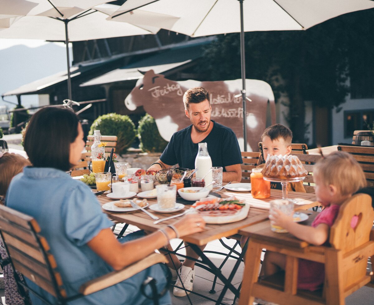 Familie sitzt im Garten bei Fruehstueck | © Urlaub am Bauernhof / Daniel Gollner