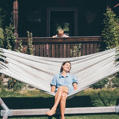 Frau in Haengematte und Kind schaut von Balkon | © Urlaub am Bauernhof / Daniel Gollner