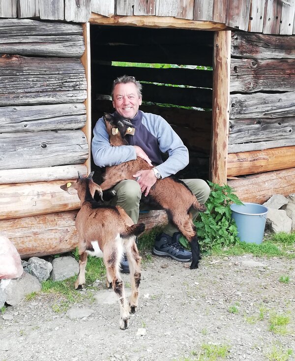 Mann umarmt Ziegen | © Urlaub am Bauernhof Österreich