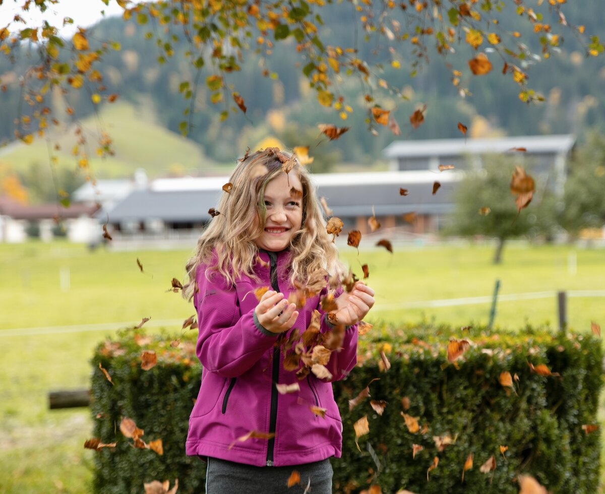 Mädchen mit Herbstlaub | © Urlaub am Bauernhof / Punkt und Komma Mädchen mit Herbstlaub | © Urlaub am Bauernhof / Punkt und Komma