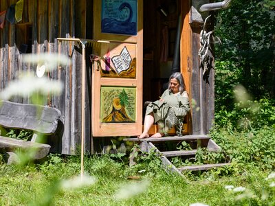 Frau sitzt auf Stufen vor einer Hütte | © Urlaub am Bauernhof Frau sitzt auf Stufen vor einer Hütte | © Urlaub am Bauernhof