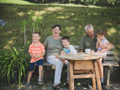 Großeltern mit Enkeln auf Sitzbank | © Urlaub am Bauernhof Österreich / Pascal Baronit Großeltern mit 3 Enkeln auf Sitzbank im Freien | © Urlaub am Bauernhof Österreich / Pascal Baronit
