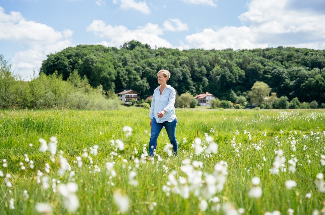 Frau geht durch lachend durch Feld | © Daniel Gollner / Urlaub am Bauernhof