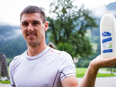 Bauer mit Milchflasche - Mei Muich, Zieferhof, Leogang im Salzburger Land | © Urlaub am Bauernhof / Matthias Gruber Jungbauer mit Milchflasche in der Hand am Zieferhof in Leogang, Salzburger Land | © Urlaub am Bauernhof / Matthias Gruber