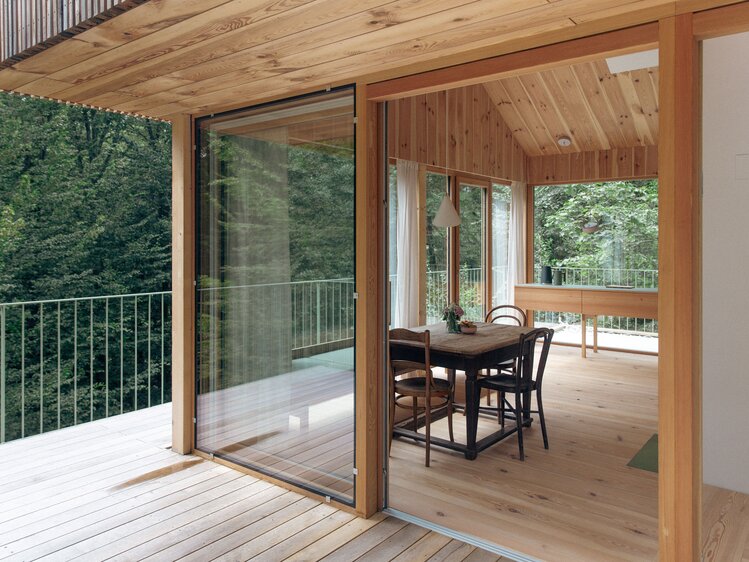 Blick von der Terrasse des Baumhauses aus Holz in den rundum verglasten Wohnraum und auf die Baumwipfel | © Urlaub am Bauernhof / Margit Terpotitz