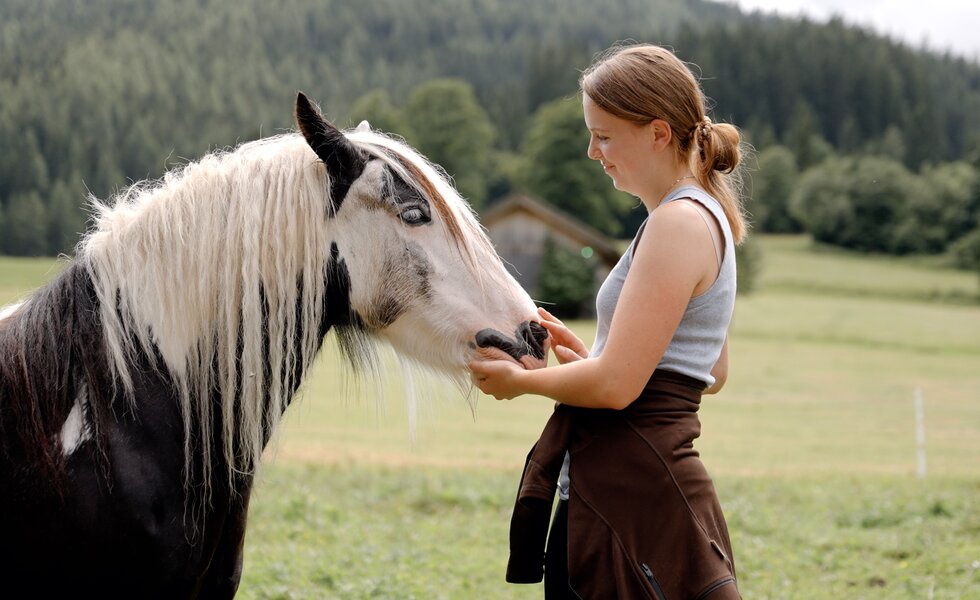 Bäuerin streichelt ein Pferd | © Urlaub am Bauernhof Steiermark / Daniel Gollner