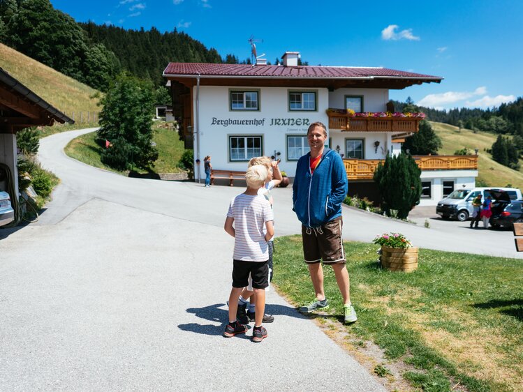Bauer steht mit Buben vor dem Bergbauernhof | © Urlaub am Bauernhof Steiermark / Daniel Gollner