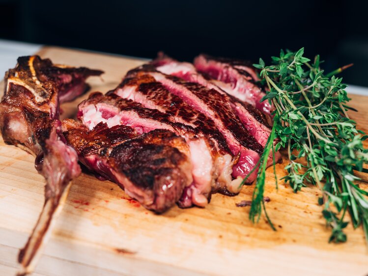 Steak aufgeschnitten mit Rosmarinzweig am Holzbrett, Lurgbauer, Steiermark | © Urlaub am Bauernhof Steiermark / Daniel Gollner
