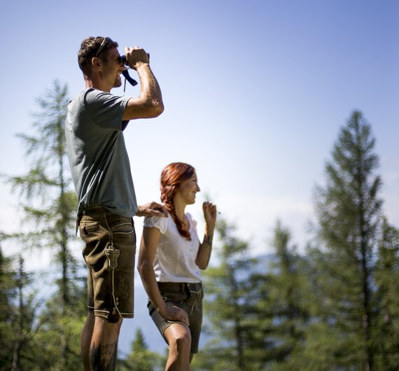 Paar blickt mit Fernglas in die Ferne, Region Hochsteiermark, Steiermark | © Hochsteiermark / Tom Lamm