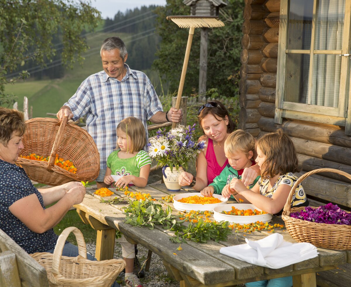 Kräuterworkshop in der Oststeiermark | © TRV Oststeiermark / Bernhard Bergmann Familie mit Kindern beim Kräuterworkshop vor einer Hütte sitzend | © TRV Oststeiermark / Bernhard Bergmann