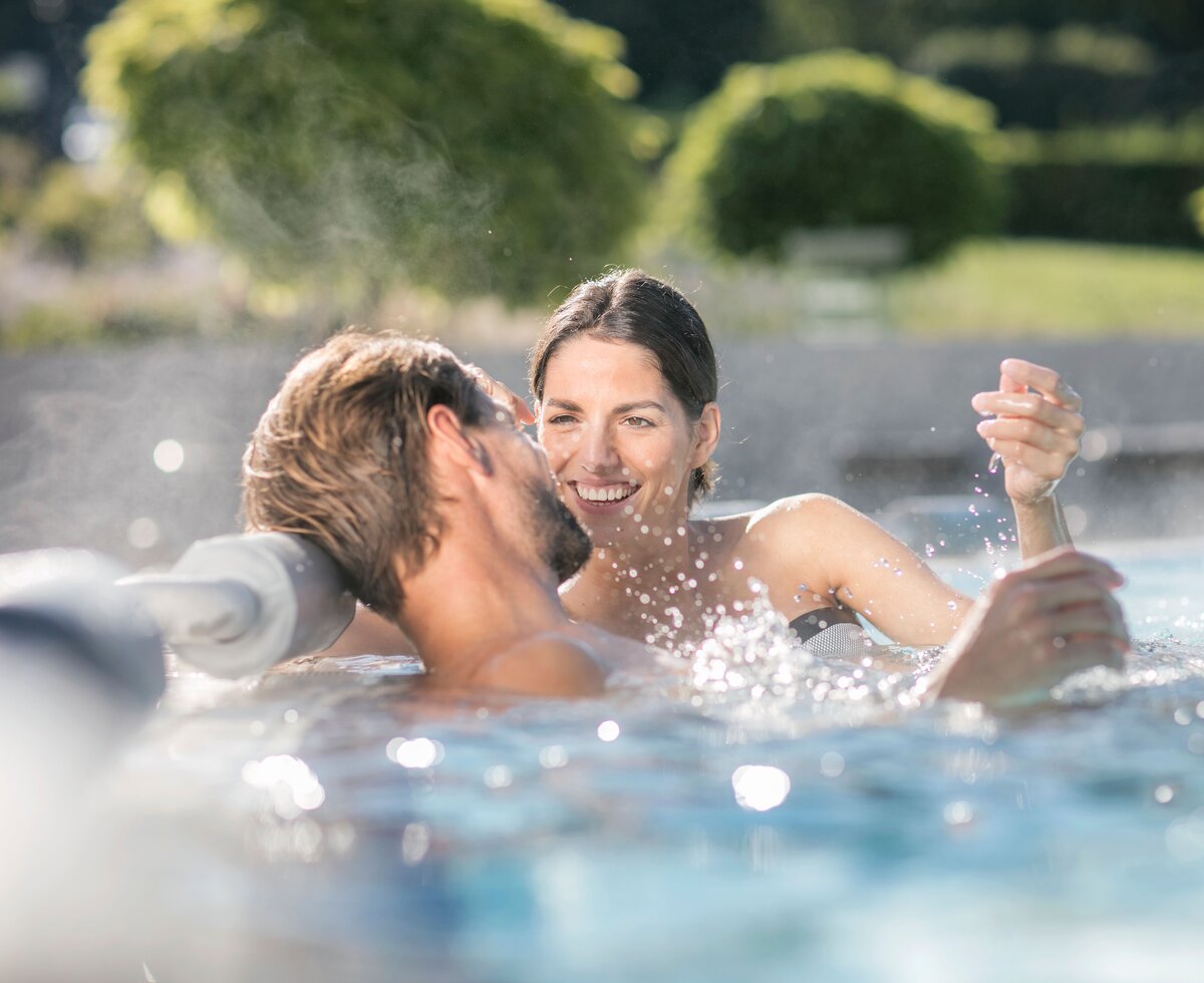Paar im sprudelnden Thermalwasser, Thermen- & Vulkanland, Steiermark | © Thermen- & Vulkanland / Harald Eisenberger Ein Paar sitzt am Beckenrand im sprudelnden Thermalwasser, Thermen- & Vulkanland, Steiermark | © Thermen- & Vulkanland / Harald Eisenberger