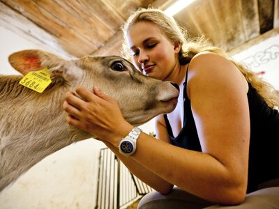 Frau streichelt Kalb, Urlaubsregion Murau-Murtal, Steiermark | © Urlaub am Bauernhof / Kufferath Frau streichelt ein Kalb im Stall, Urlaubsregion Murau-Murtal, Steiermark | © Urlaub am Bauernhof / Kufferath