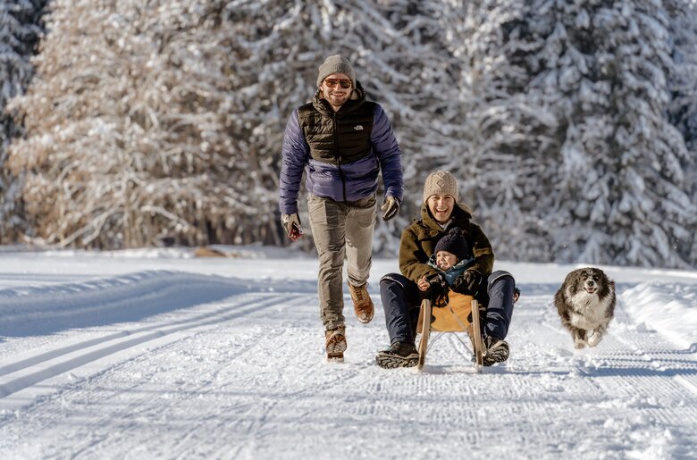 Familie fährt mit dem Schlitten in der Winterlandschaft | © UaB Steiermark / Wolfgang Spekner