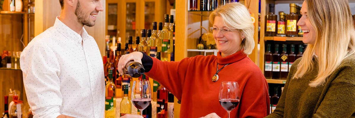 Winzerin und junges Paar bei der Weinverkostung im Hofladen, Süd-West-Steiermark, Steiermark | © Urlaub am Bauernhof Steiermark / Wolfgang Spekner