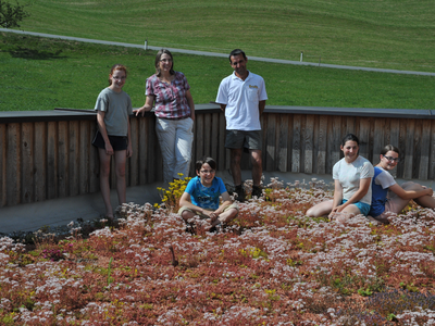 Familie auf der Terasse die mit Blumen und Kräutern übersäät ist | © Urlaub am Bauernhof Vorarlberg / Familie Lingenhel Familie Lingenhel auf der Terasse | © Urlaub am Bauernhof Vorarlberg / Familie Lingenhel
