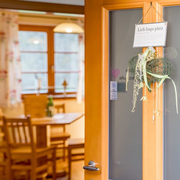 Eingang zum Buchgrabenhof mit Holztisch und Stühlen, geschmückt mit einem 'Lieblingsplatz'-Schild.
