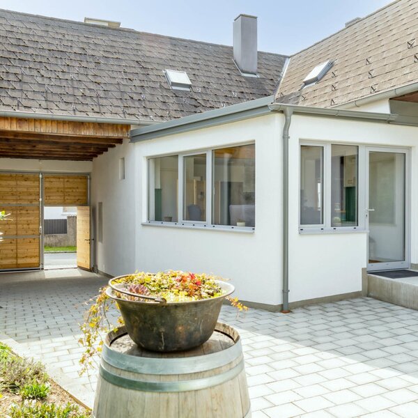 Außenbereich des Bed and Breakfast mit gepflastertem Hof und überdachtem Zugang.