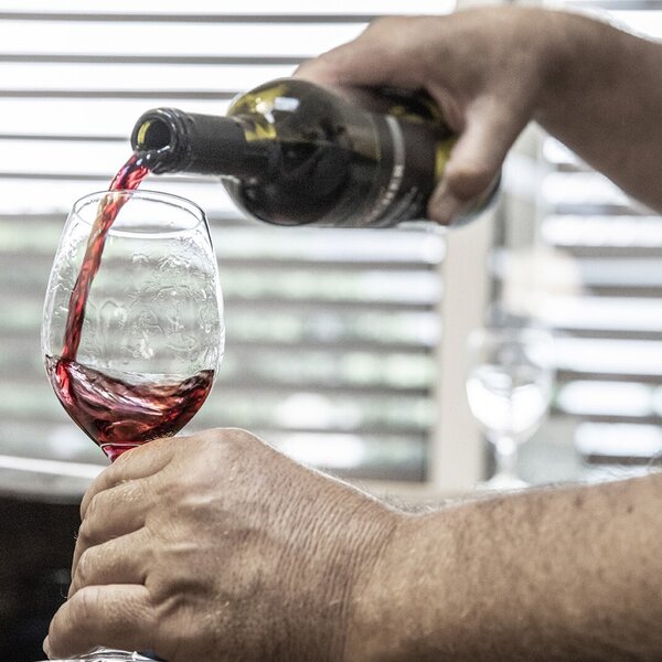 A glass of red wine is poured, available as an offering at the farmhouse.