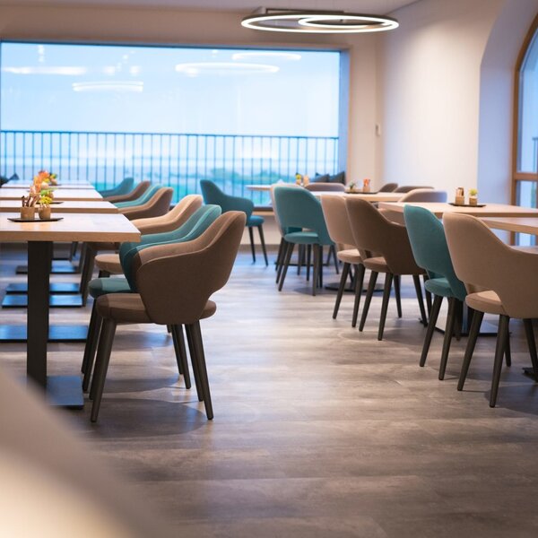 The dining and lounge area at the farmhouse offers various tables and seating arrangements, with large windows providing natural light and views.