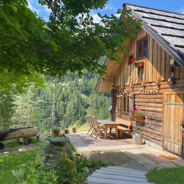Vor der Hütte befindet sich ein Brunnen mit frischem Quellwasser sowie eine Sonnenterrasse mit Tisch und Sitzmöglichkeiten
