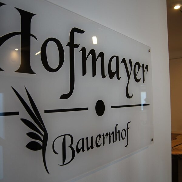 The glass sign displaying 'Hofmayer Bauernhof' for the farm house.