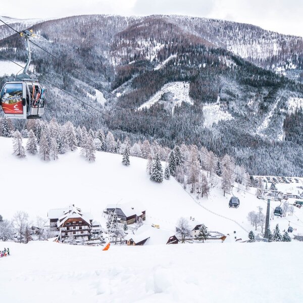 The snowy mountain environment with ski slopes, gondolas, and ski lifts, available for guests staying at the Farm House.