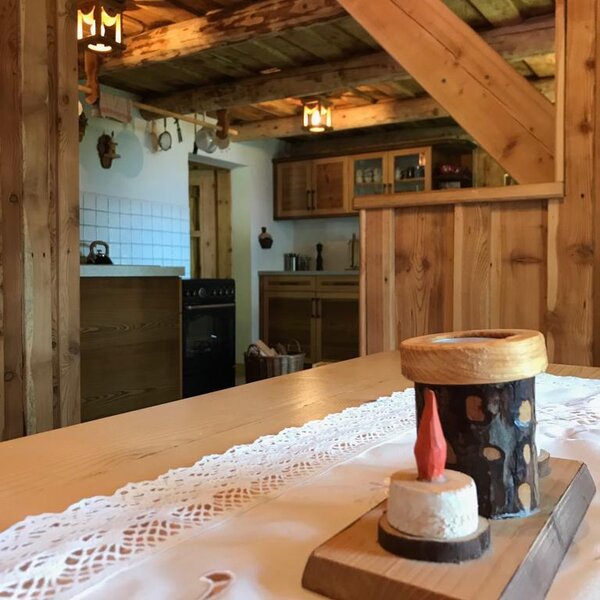 Der Essbereich und die offene Küche des Hofes mit sichtbaren Holzbalken.