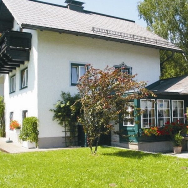 Die Außenansicht des Bauernhofs mit großem Garten und Balkon.