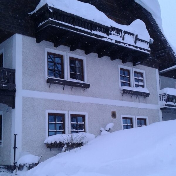Der schneebedeckte Bauernhof mit Balkonen.