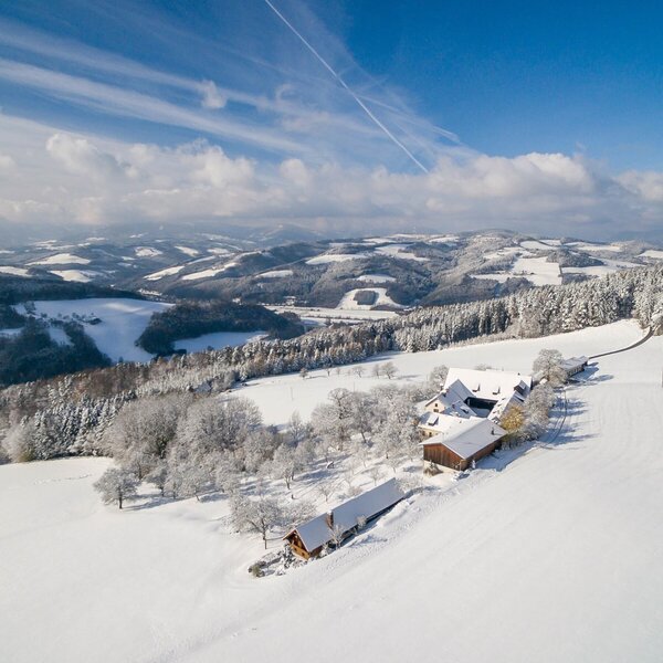 The Farm House is situated on a sunny, snow-covered slope with panoramic views of the surrounding hills.