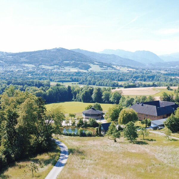Malerischer Blick auf den von Wiesen und Wäldern umgebenen Bio-Bauernhof mit dem gemütlichen Appartement im oberösterreichischen Alpenvorland. | © Urlaub am Bauernhof Oberöstereich/Karin Trausner