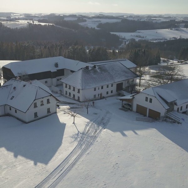 Der Grainmeisterhof mit seinen Gebäuden inmitten einer schneebedeckten Winterlandschaft.
