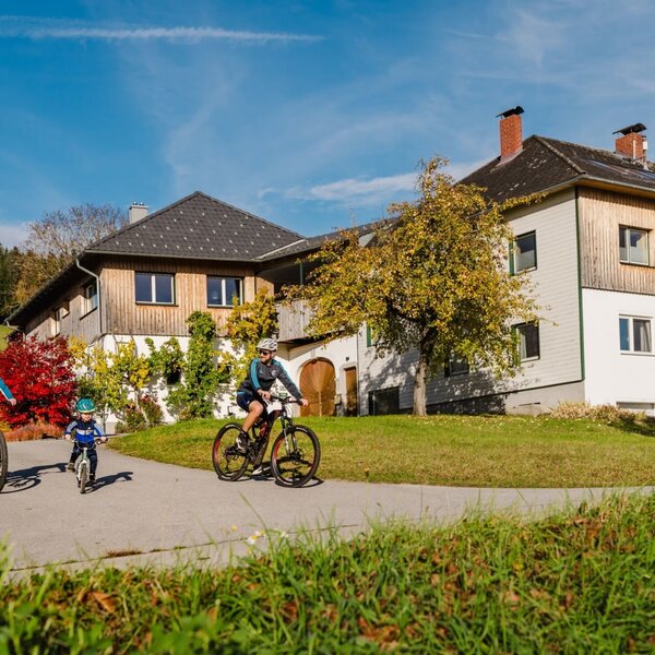 The Bauernhof with guests cycling on the path, ideal for outdoor activities in nature.