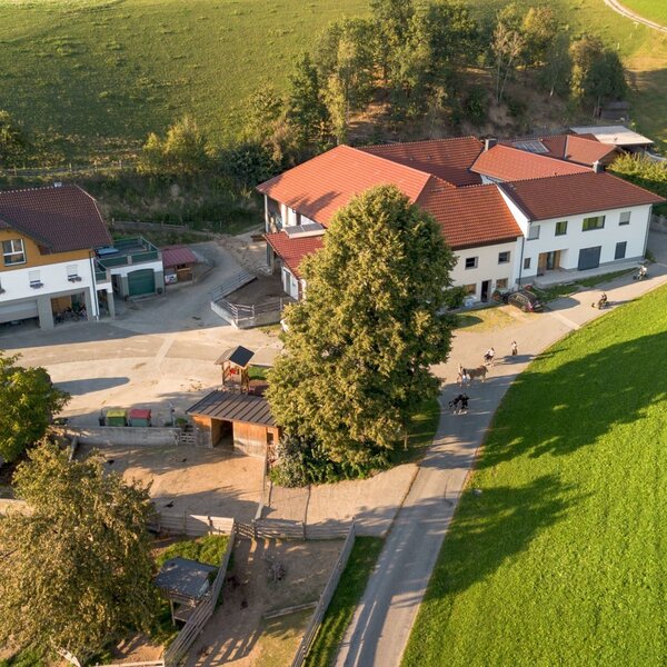 Luftaufnahme des Bauernhofs, umgeben von grünen Feldern