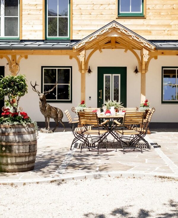 Die Terrasse der Appartements mit Außensitzgelegenheiten und dekorativen Pflanzen in Weinfässern. | © Urlaub am Bauernhof Oberösterreich / Bettina Gangl