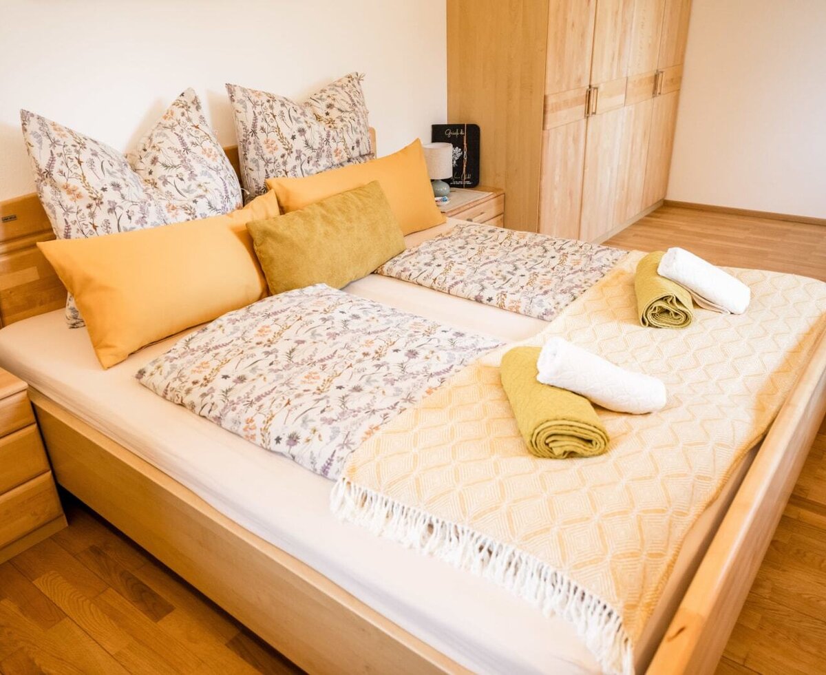 Doppelbettzimmer im Bauernhof mit Nachttischen und Kleiderschrank.