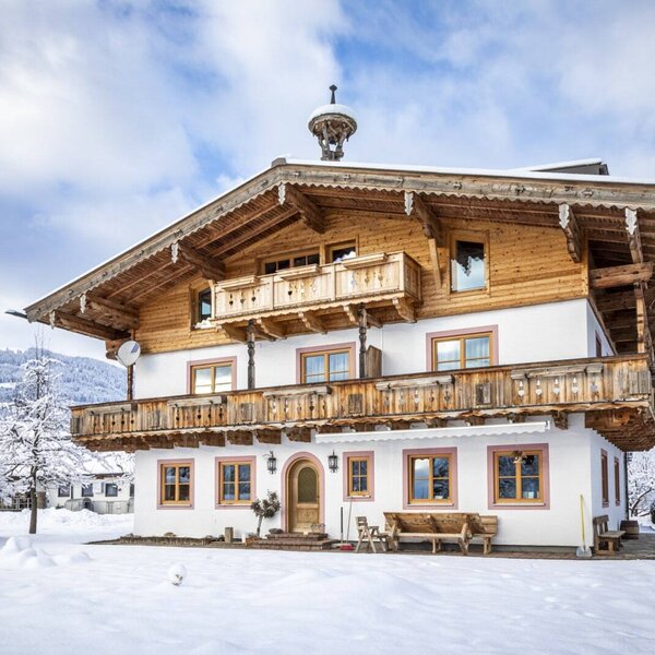 The Farm House exterior during winter, featuring multiple wooden balconies and snow-covered grounds.