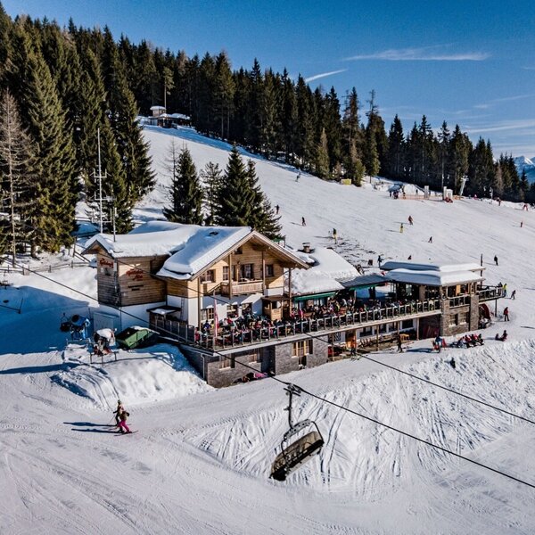 Der Hof bietet eine große Sonnenterrasse direkt an der Skipiste mit Blick auf die Berge.