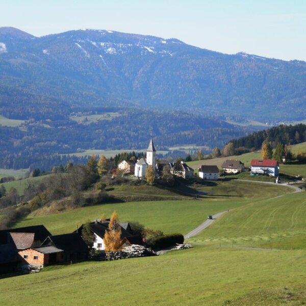 The surrounding landscape of the Farm House, featuring a village with a church, green fields, and mountains.