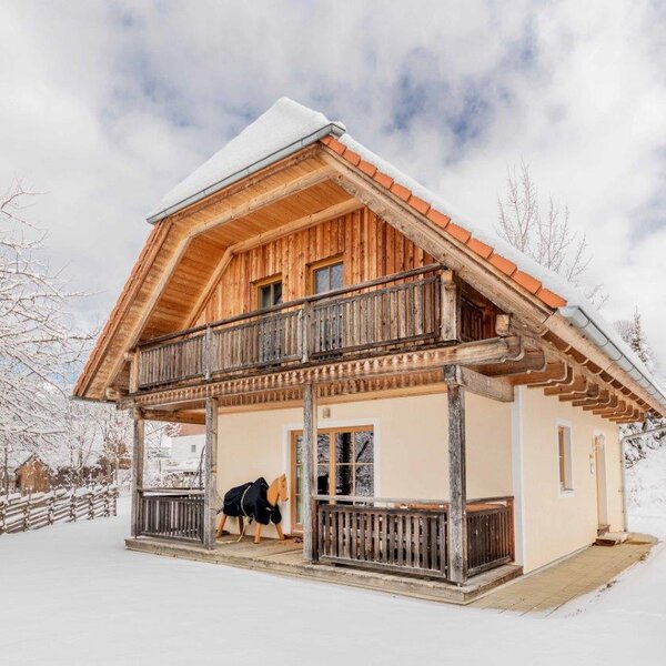 Das Ferienhaus auf dem Bauernhof mit Holzbalkon und überdachter Terrasse im Winter.