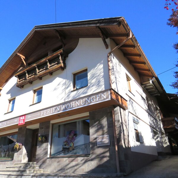 The exterior of the farm house features traditional wooden balconies and ground-floor windows for holiday apartments.
