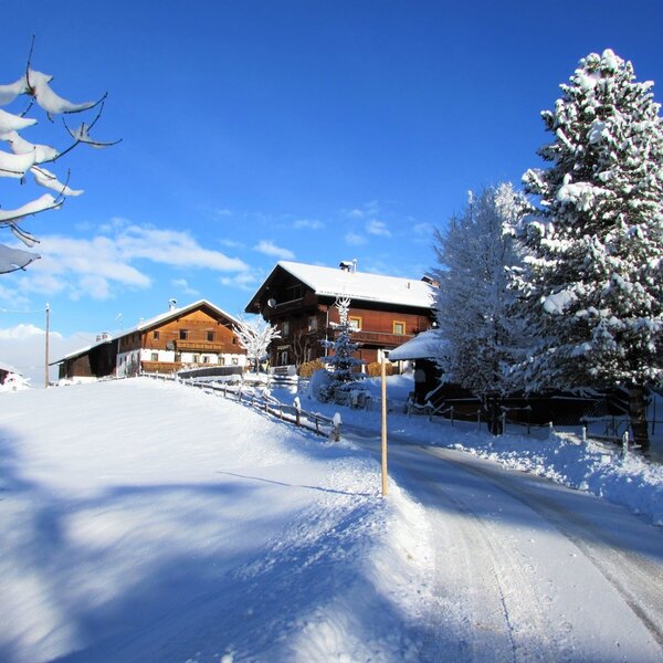The Farm House exterior in a snow-covered landscape under a clear blue sky.