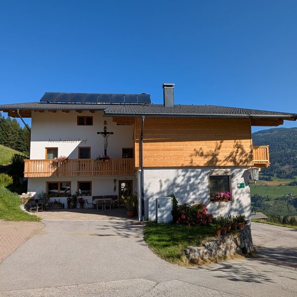 The farmhouse with balconies and a terrace overlooking the mountains.