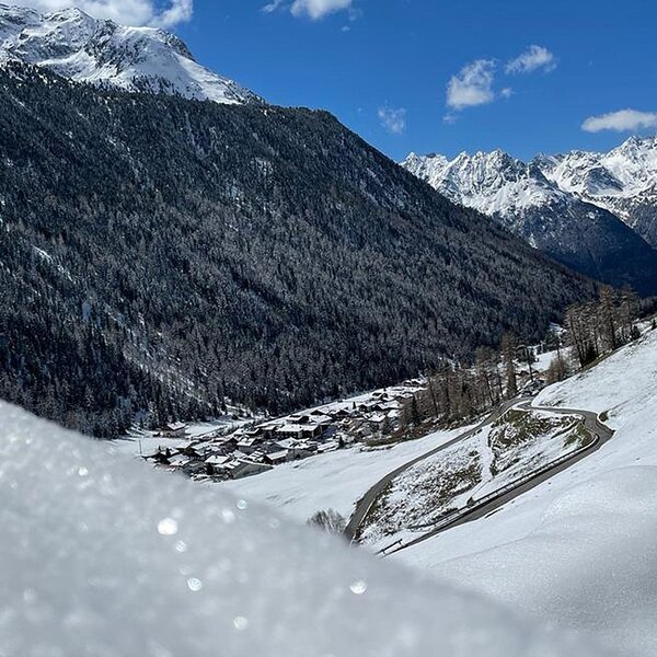 The snow-covered mountain valley surrounding the Farm House, featuring a village and a winding road.