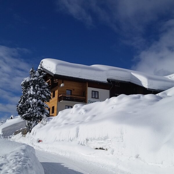 Die Außenansicht des Bauernhofs im Winter, umgeben von tiefem Schnee.