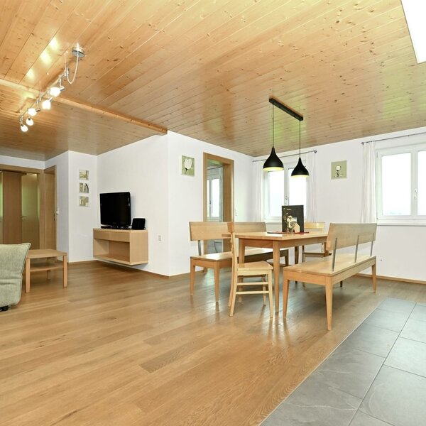 Der offene Wohnbereich der Ferienwohnung mit Sofa, TV, Esstisch und der vollausgestatteten Wohnküche.